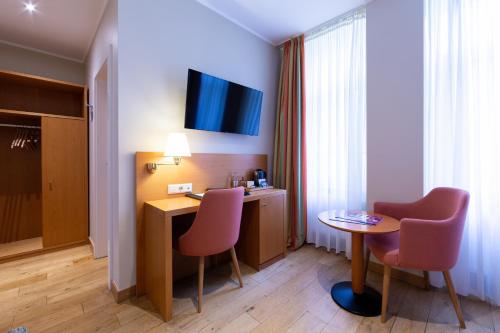 Télévision ou salle de divertissement dans l'établissement Hotel Perrin - former Carlton