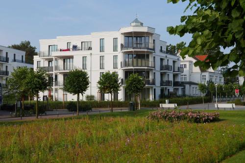 a white building with a park in front of it at Baabe Villen Ensemble FeWo 12 Meer in Baabe