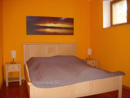 a bedroom with a bed and two night stands with lamps at Fewoamglubigsee in Wendisch Rietz
