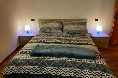 a bedroom with a large bed with two lamps at Casa Vacanze Roure " BAITA PECIT PARI" in Roure Turin