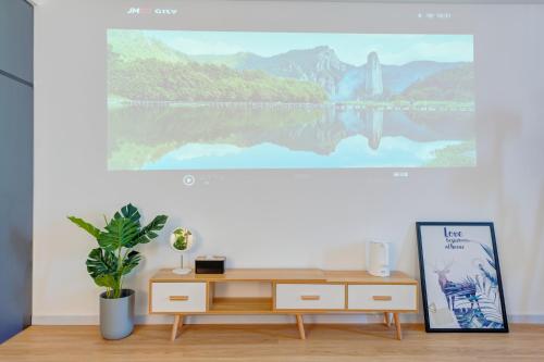 a desk in a room with a painting on the wall at Lavender Apartment in Guangzhou
