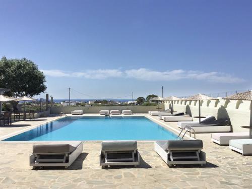 una piscina con sedie a sdraio e sedie a sdraio accanto ad essa di Thera Mare a Perissa