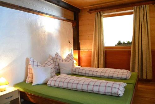 two beds in a room with a window at Haus Pfauth in Tannheim