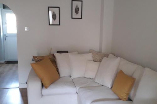 a white couch with yellow pillows in a living room at Demesnes View in Barnard Castle