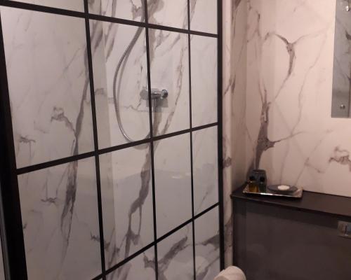 a bathroom with a shower with marble walls at Demesnes View in Barnard Castle