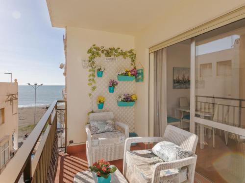 Il comprend un salon avec des chaises et un balcon donnant sur l'océan. dans l'établissement Belvilla by OYO Cozy apartment, à Rincón de la Victoria