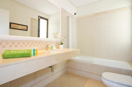a bathroom with a sink and a toilet and a tub at Ereza Villas Las Buganvillas in Playa Blanca