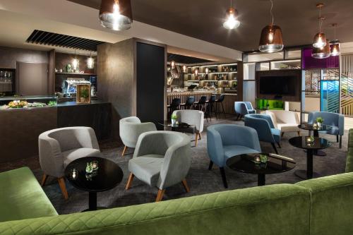 hol z zieloną kanapą i krzesłami oraz barem w obiekcie Holiday Inn Rome - Eur Parco Dei Medici by IHG w Rzymie