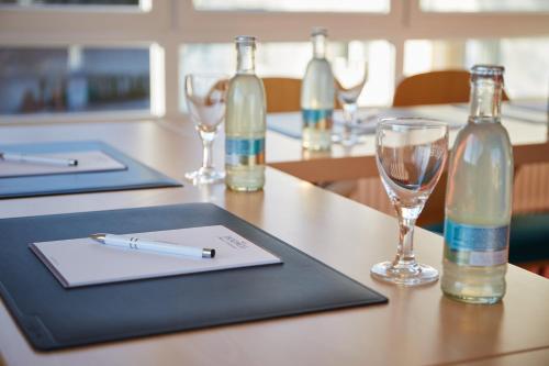 a table with two bottles and a pen and glasses at Berghotel Tambach in Tambach-Dietharz
