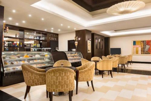 a restaurant with a bunch of tables and chairs at Ramada Plaza by Wyndham Karachi Airport Hotel in Karachi