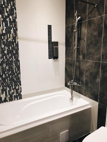 un baño con ducha y bañera en Bai Sha Tan Cottage, en Kenting