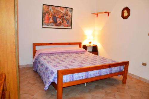 リド・マリーニにあるCasa Vacanza CALALUNAのベッドルーム1室(ベッド1台、壁掛け時計付)