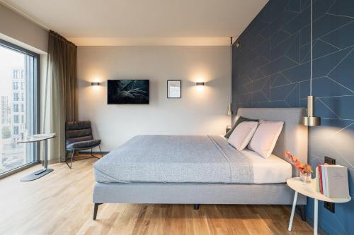 a bedroom with a large bed with a blue wall at ipartment Frankfurt Airport in Frankfurt/Main