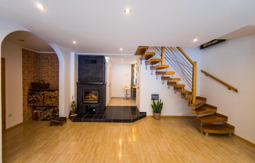 a living room with a staircase and a fireplace at WILLA MAŁGORZATA DOM na WYŁĄCZNOŚĆ in Wisła