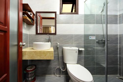 a bathroom with a toilet and a sink and a mirror at Homestay May Trang in Hoi An