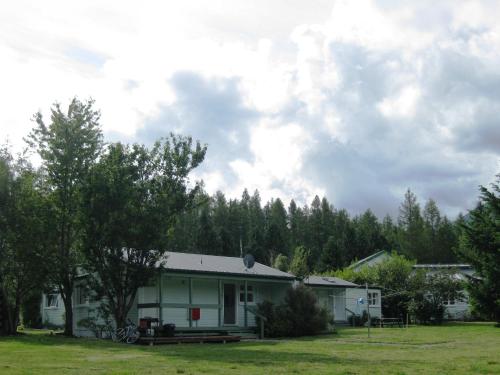 a house in a field with trees in the background at Alpine Holiday Apartments & Campground in Hanmer Springs