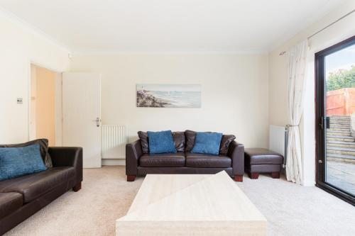 a living room with two couches and a table at Drayton Manor House FREE parking in Tamworth