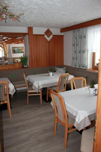 a dining room with two tables and chairs at Hotel Pension Siggi in Sankt Leonhard im Pitztal