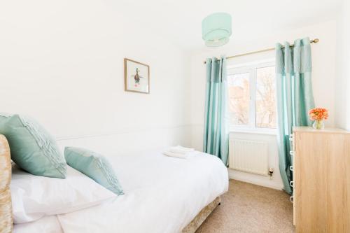 a bedroom with a bed with blue curtains and a window at Drayton Manor House FREE parking in Tamworth