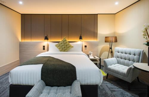 a hotel room with a bed, chair, and table at Aerotel London Heathrow, Terminal 2 & Terminal 3 in Hillingdon