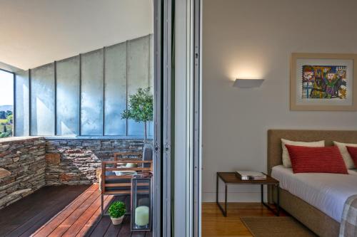 a bedroom with a bed and a balcony at CASA QTA. STA. CRUZ-RÉGUA in Peso da Régua