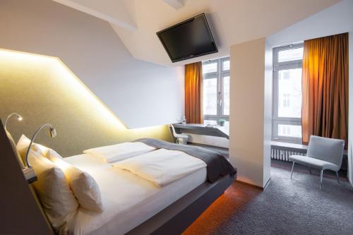 a hotel room with a bed and a flat screen tv at Aspria Berlin Ku'damm in Berlin