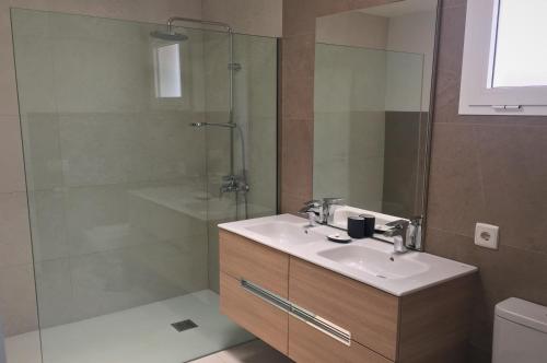 een badkamer met een wastafel en een douche bij Villalia Patricia in Playa Blanca