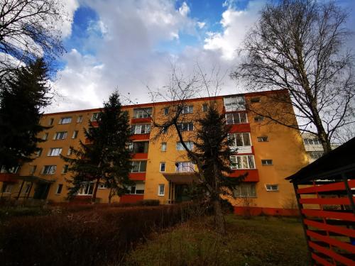 un edificio de apartamentos con árboles delante de él en Garsoniera Flamingo Garii 4 en Braşov