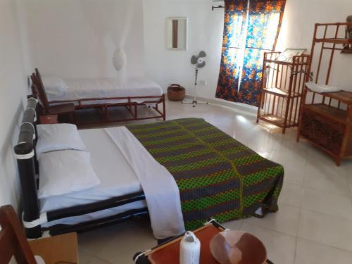 een slaapkamer met 2 aparte bedden en een raam bij Kinkiliba Beach Lodge in Sanyang