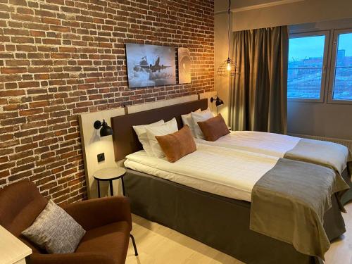 a bedroom with a bed and a brick wall at Skyline Airport Hotel in Vantaa