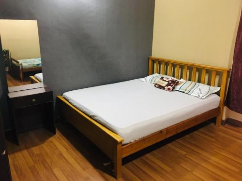 a small bed in a room with a mirror at Az Zahra Homestay KLIA Sepang in Sepang