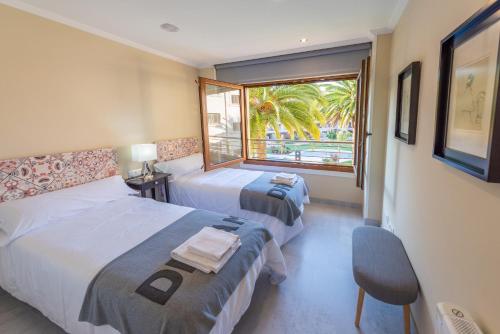 a hotel room with two beds and a window at Nuevo apartamento en Isla de la Toja in Isla de la Toja