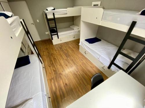 a small room with two bunk beds and a table at Visto Hostel in Sao Paulo