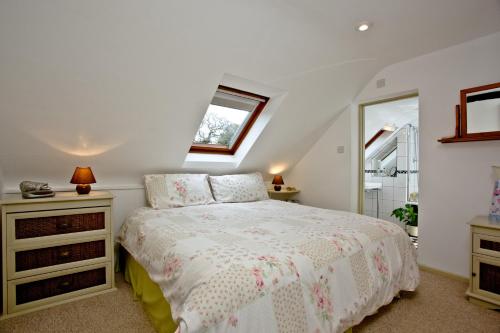 een witte slaapkamer met een bed en een raam bij Smallicombe Farm in Colyton
