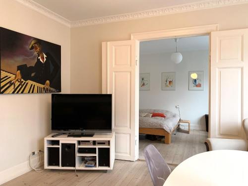 sala de estar con TV de pantalla plana en un soporte en ApartmentInCopenhagen Apartment 1436, en Copenhague