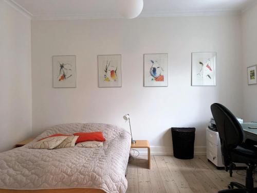 a bedroom with a bed and some pictures on the wall at ApartmentInCopenhagen Apartment 1436 in Copenhagen