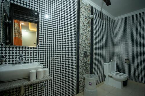 a bathroom with a sink and a toilet and a mirror at Yes Boss By Backpackers Heaven Near New Delhi Train Station in New Delhi