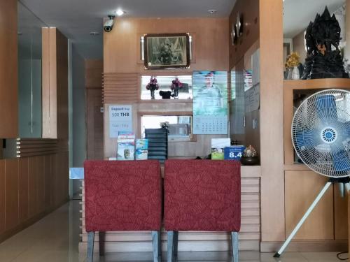 a room with two red chairs and a fan at Le Desir Resortel in Chalong