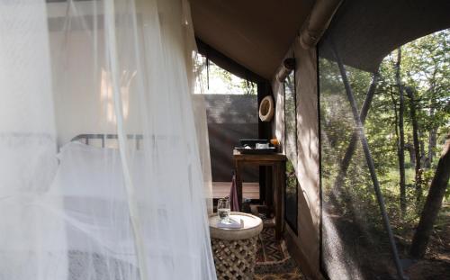 a bedroom with a curtain and a sink in a tent at Simbavati Trails Camp in Timbavati Game Reserve