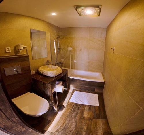 a bathroom with a toilet and a sink and a tub at Hotel Ranč u Edyho in Námestovo