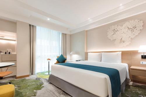 a hotel room with a large bed and a table at Holiday Inn Bangkok by IHG in Bangkok