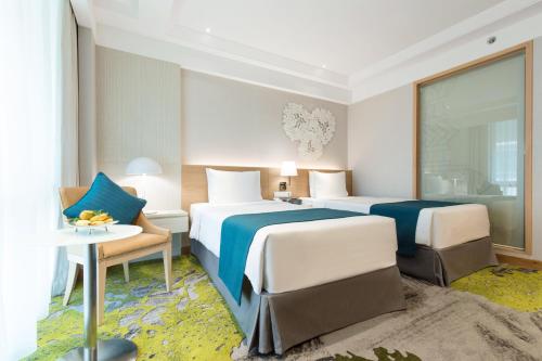 a hotel room with two beds and a table at Holiday Inn Bangkok by IHG in Bangkok