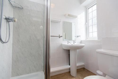 a white bathroom with a sink and a shower at Station Approach Solihull Cabin Stays in Solihull