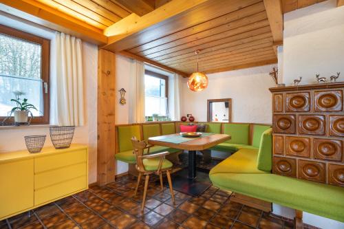 une salle à manger avec des chaises vertes et une table dans l'établissement Ferienwohnungen Alpentraum - Ferienhaus Schmid, à Oberstdorf