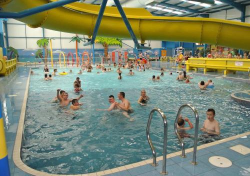 a group of people in a swimming pool at ML66 8 BERTH CARAVAN GOLDEN PALM CHAPEL ST LEONARDS in Chapel Saint Leonards