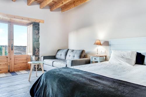 ein Schlafzimmer mit einem Bett und einer Couch in der Unterkunft Villa Tranquila in Villaverde