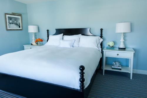 a blue bedroom with a large bed with white pillows at Congress Hall in Cape May