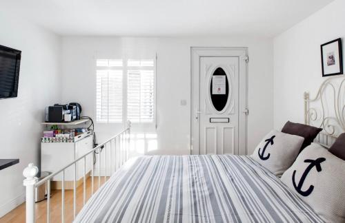 um quarto branco com uma cama e uma porta em Studio, Private, independant Entrance, Central, Battersea Park em Londres