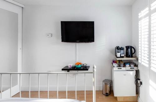 sala de estar con TV en una pared blanca en Studio, Private, independant Entrance, Central, Battersea Park, en Londres