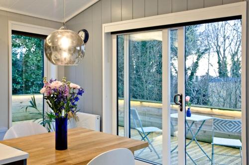 a dining room with a table with a vase of flowers at The Levels, Strawberryfield Park, Cheddar in Cheddar